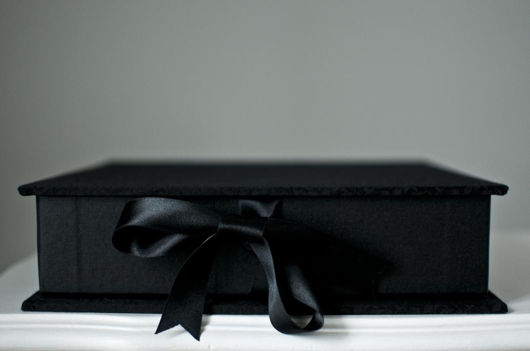 Black brocade. 10 inch square format with ribbon tie closures.